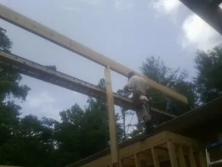 Carpenter setting a ridge beam over a new addition frame — Ice Dam Removal by Roofing Brothers in Fleischmanns