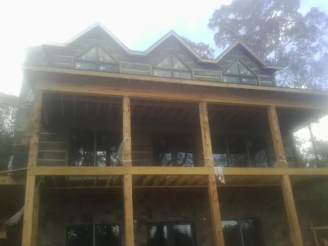 Dormers and porch framing on a large log home under construction — Roof Coating work by our crew in Fleischmanns