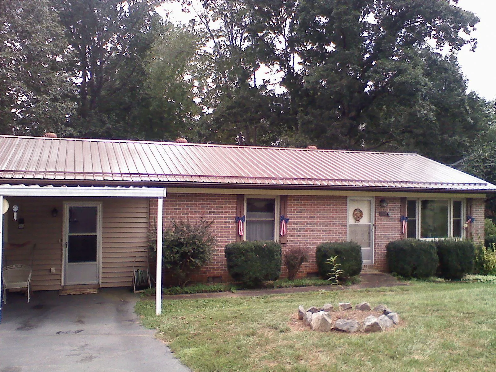 Bronze metal roof and carport on a brick ranch home — Roof Repair work by our crew in Fleischmanns